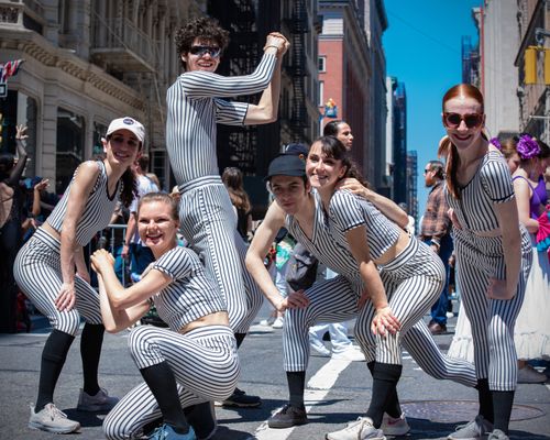 Free A lively dance group poses in matching striped outfits on a sunny day in New York City. Stock Photo