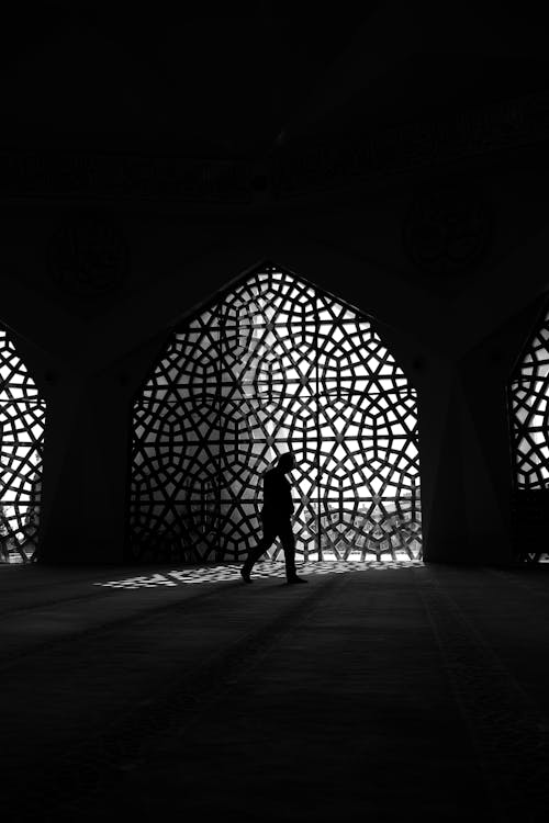 Silhouette of a Person Walking in a Dark Room