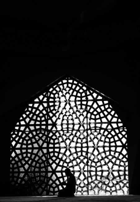 A contemplative moment in Istanbul's ornate architecture highlights spirituality and geometric design.