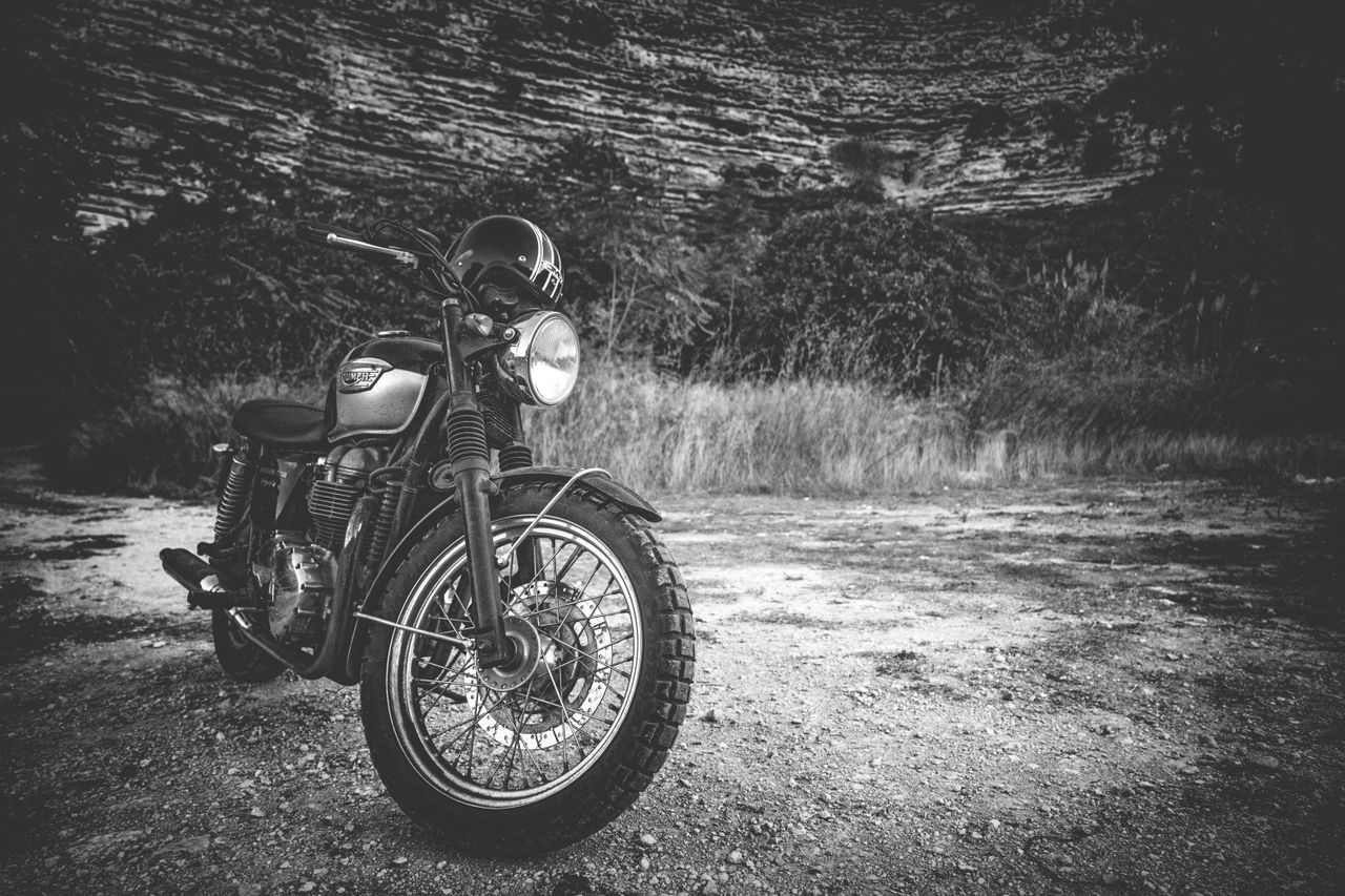 classic triumph motorcycle parked outdoors in a black and white settin