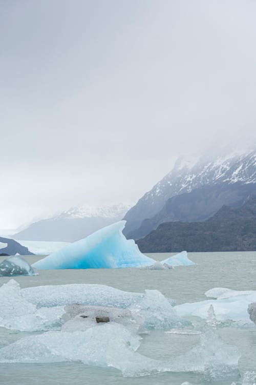 Icebergs Floating on the Sea Surface and Mountains 