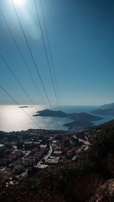 Fotomural Una vista impresionante de un pueblo costero con vistas a islas y océano bajo cielos despejados.