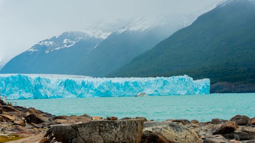 Mountain Landscape with a Glacier, and a Ferry on the Lake