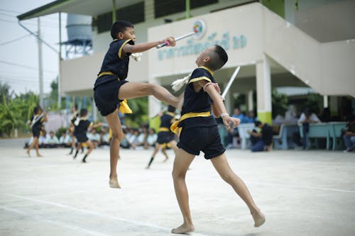 Photography of a Boy Kicking Another Boy