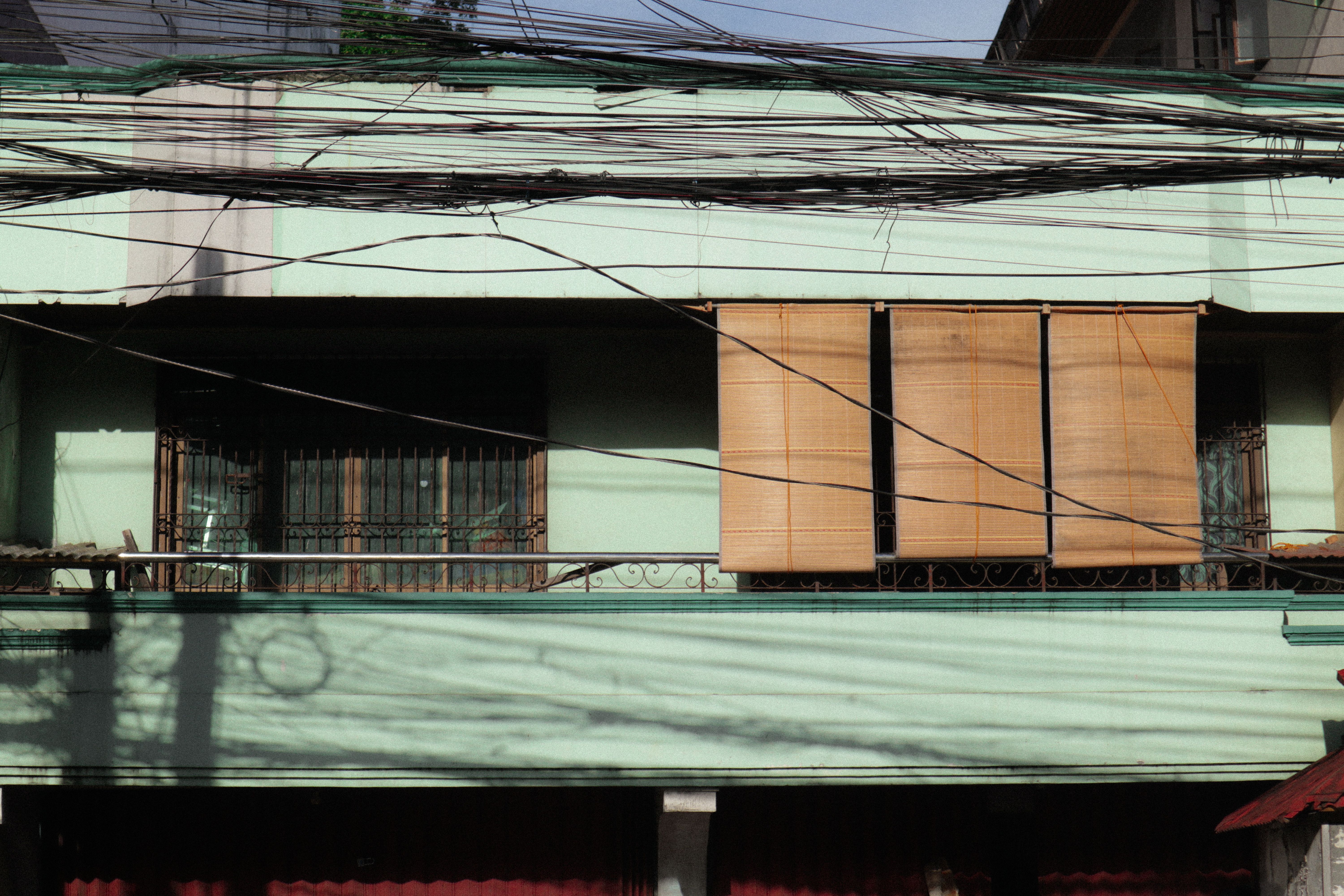 Picture of Green Apartment Building Near Electric Lines · Free Stock Photo