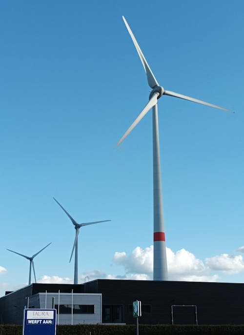 White Wind Turbines Under Blue Sky