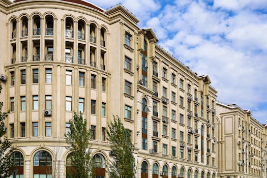 A classic urban residential building with rounded corners and detailed facades under a clear blue sky.