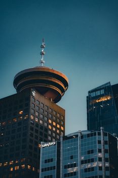 Modern architecture in Vancouver, BC featuring the iconic Vancouver Lookout against the evening sky.