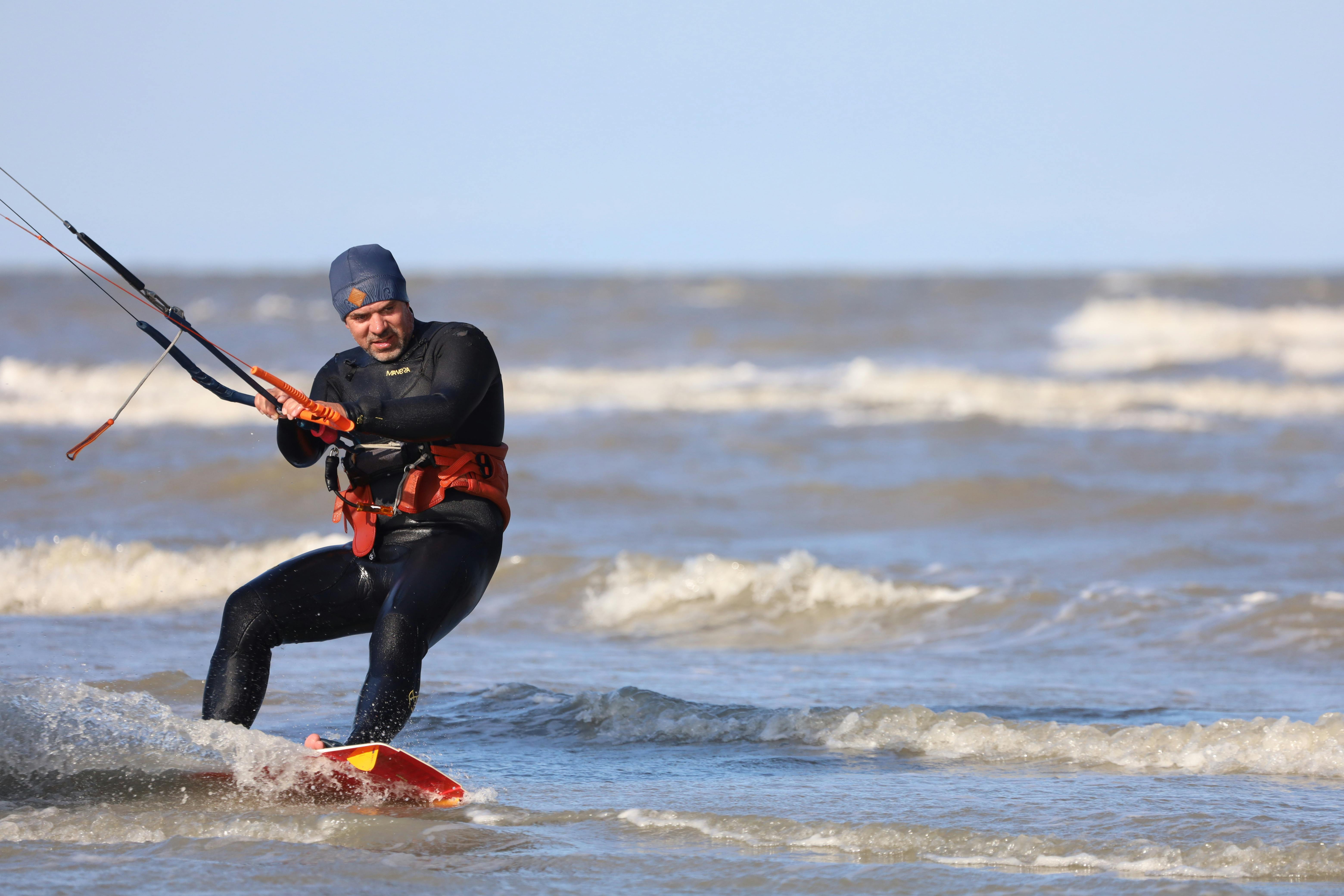 Man in Black Wetsuit Kite Surfing on the Ocean · Free Stock Photo