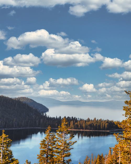 Free Calm lake surrounded by pine trees and a cloudy sky, offering a tranquil nature scene. Stock Photo