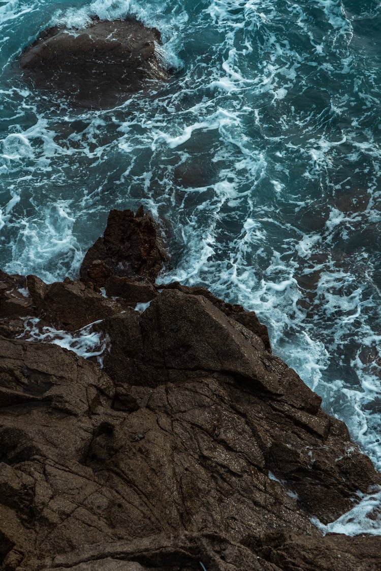 High Angle Shot Of A Rock And Sea