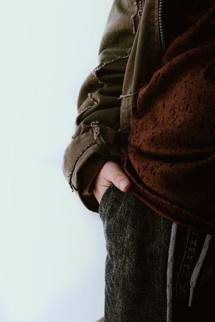 Close-up of an olive fleece layer with a hand in the pocket — photo by Emmanuel Hernandez on Pexels