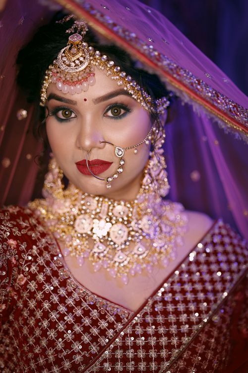 Free Stunning portrait of a woman in traditional South Asian bridal attire, adorned with intricate jewelry. Stock Photo