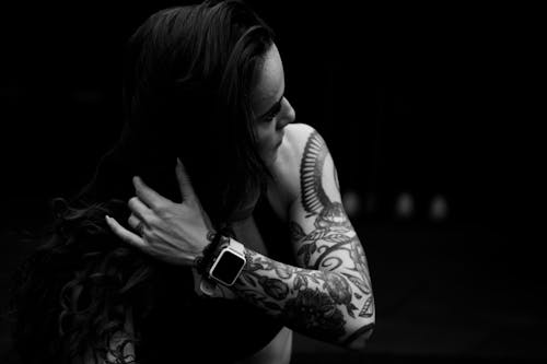 Grayscale Photo of a Tattooed Woman