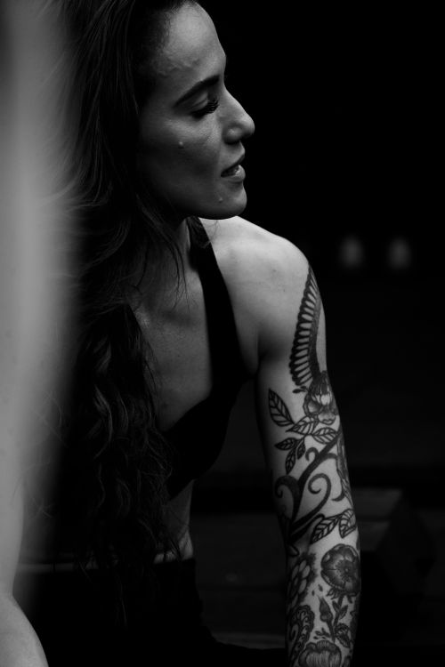 Free Artistic black and white portrait highlighting intricate tattoos on a woman's arm. Stock Photo