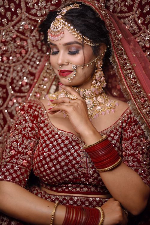 Free A stunning Indian bride in red traditional attire, adorned with intricate jewelry. Stock Photo