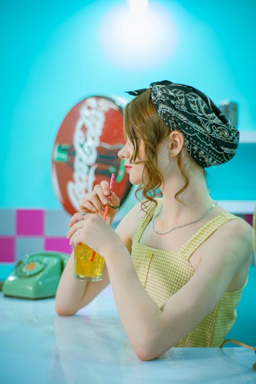 A Woman in Yellow Tank Top Holding a Drink