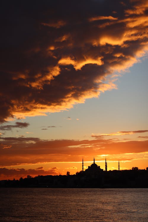Silhouette of a Mosque against Yellow Sunset Sky, and Dramatic Cloud