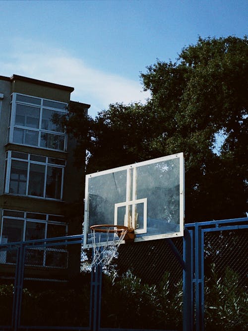 Blue Basketball Hoop Beside a Fence