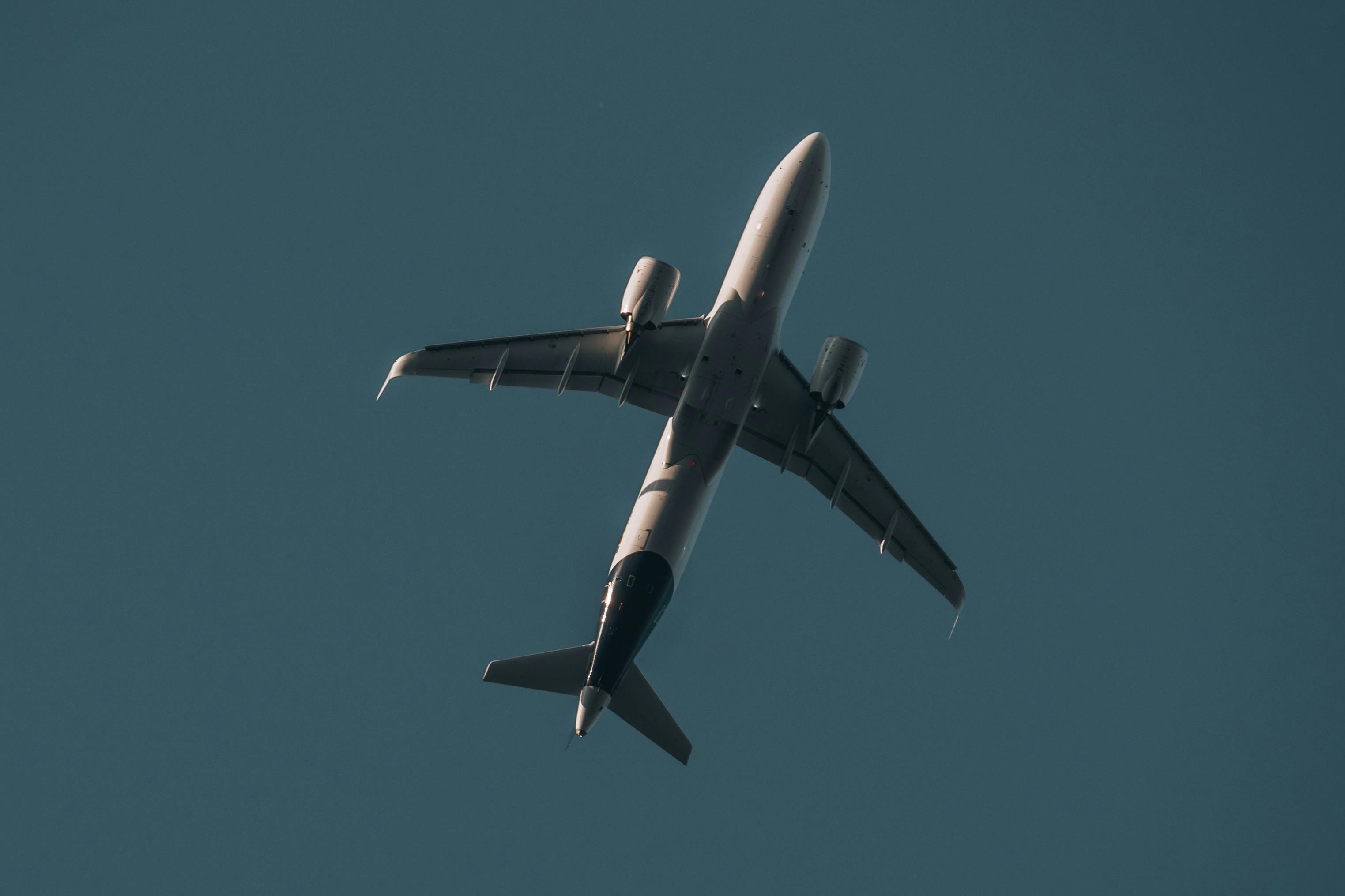 Close Up Photo of Airplane Flying Under Blue Sky · Free Stock Photo