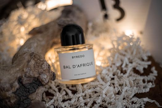Byredo Bal D'Afrique perfume surrounded by folded papers in a stylish still life setup.