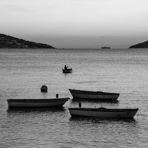 Grayscale Photo of Boats on the Ocean