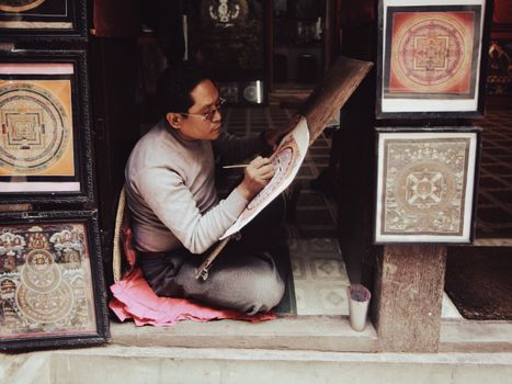 An artisan carefully painting an intricate mandala, showcasing traditional craftsmanship.