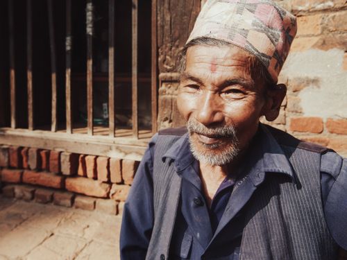 Free Elderly man wearing traditional Nepalese clothing, smiling outdoors. Stock Photo