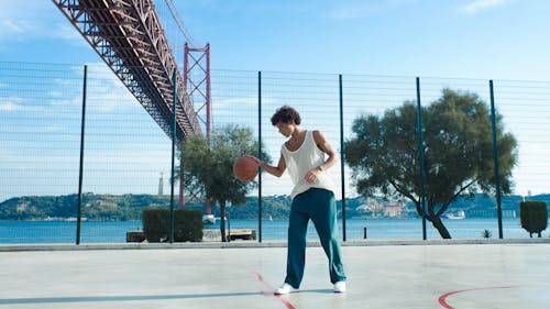 A Man in a Tank Top Playing Basketball