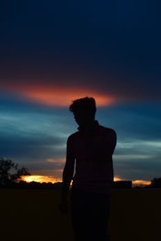 A stunning silhouette of a man against a colorful sunset sky in Bhubaneswar, India.