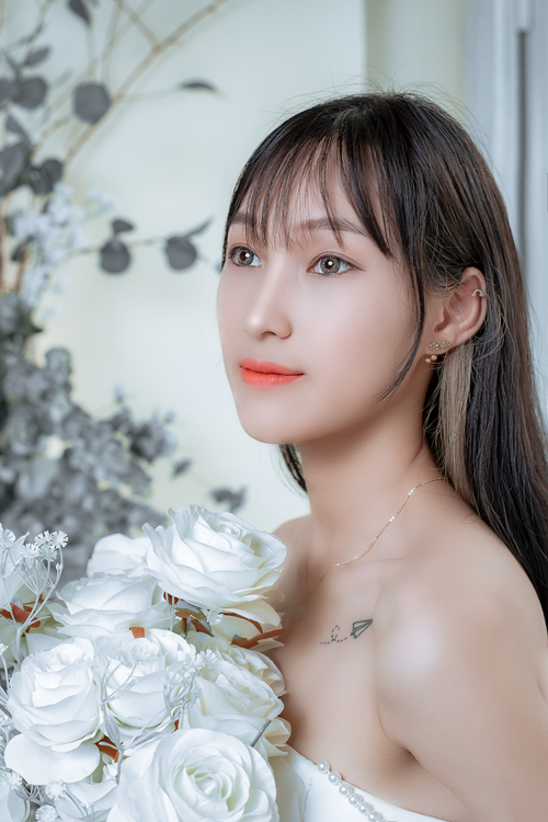 Free Beautiful portrait of a woman holding white roses, exuding elegance and grace. Stock Photo
