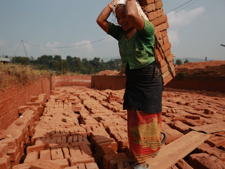 A Person Carrying Red Bricks 