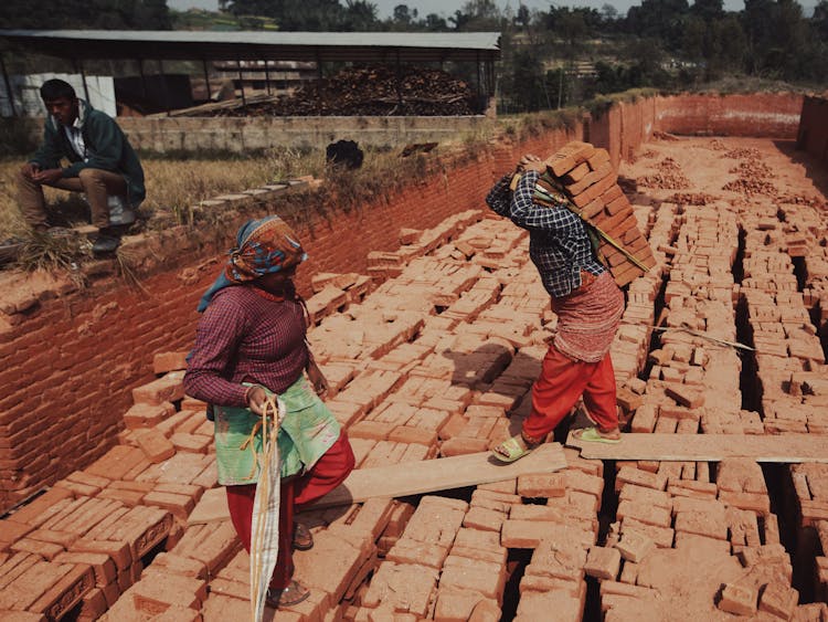 A Person Carrying Red Bricks