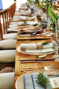 这张布置精美的餐桌特写，配有鲜花和餐具，非常适合婚礼或高级餐饮场合