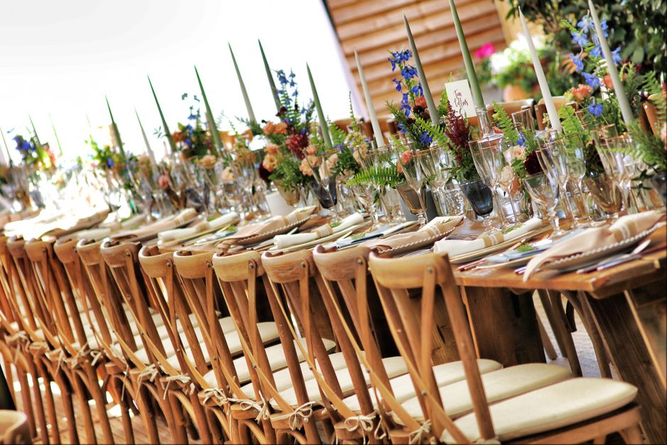Row of set banquet chairs along a flower-dressed wedding table