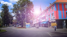 城市街景中，色彩缤纷的建筑和明亮的阳光下，有几个人在散步