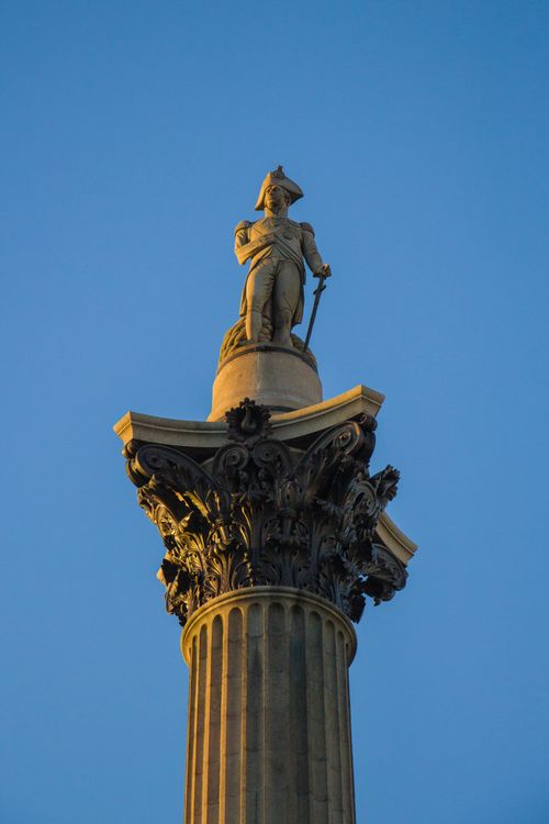 Free A detailed view of Nelson's Column in Trafalgar Square, London, against a clear blue sky, showcasing its majestic architecture. Stock Photo