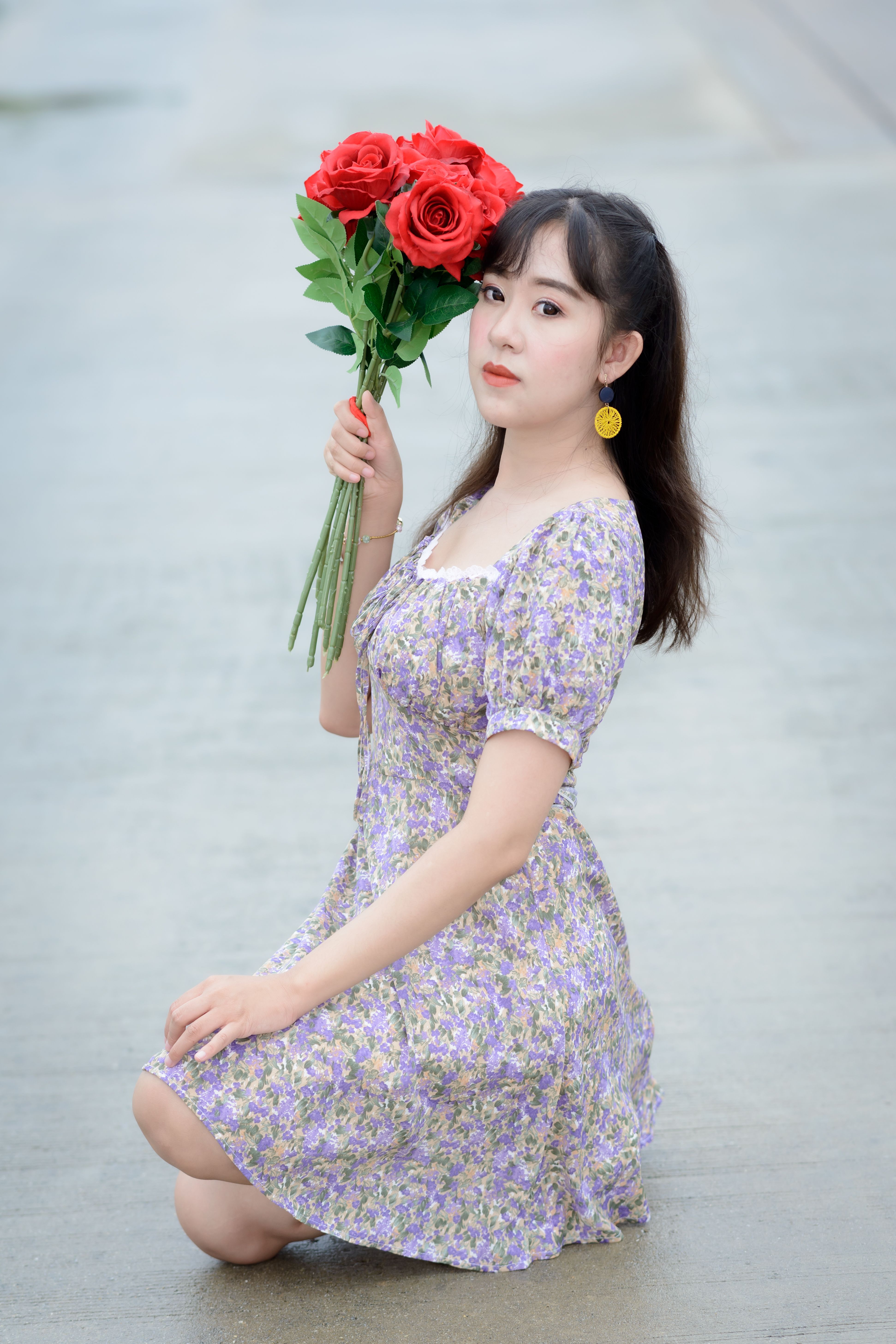Woman in Floral Dress Holding Red Flowers · Free Stock Photo