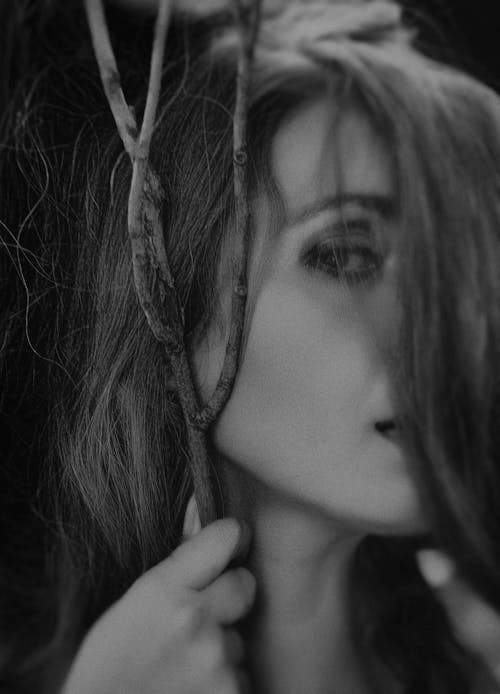 Shallow Focus Photography of Woman Holding Branch