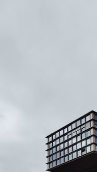 A modern building with a minimalist design against a gray sky, offering ample copy space.