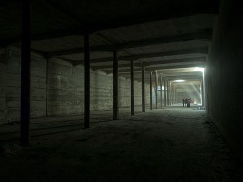 Free Long corridor in a construction site with sunlight streaming in, creating a dramatic effect. Stock Photo