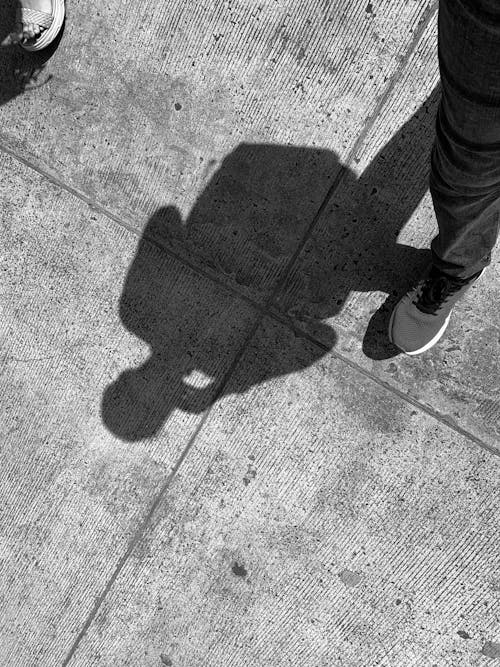 Shadow of a Person Walking on the Concrete  Road 