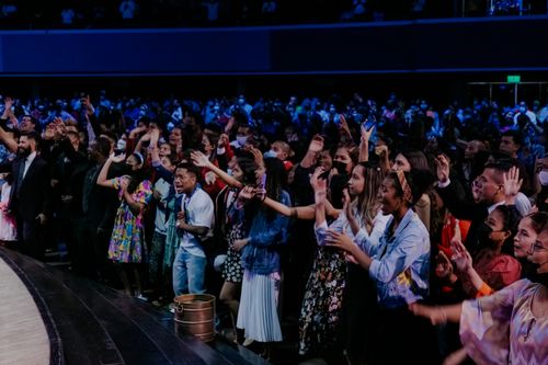 Free Large group of diverse people celebrating energetically at a lively indoor event. Stock Photo