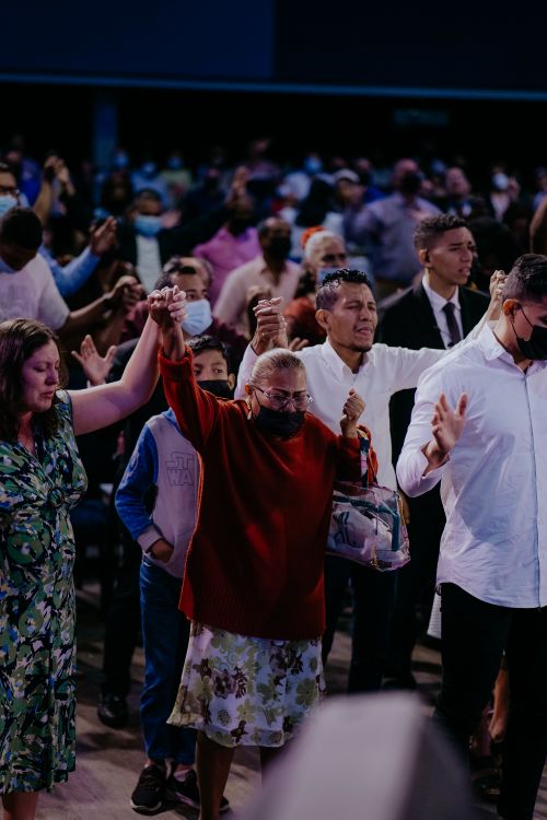 Free A diverse group wearing masks participates in a worship event indoors. Stock Photo
