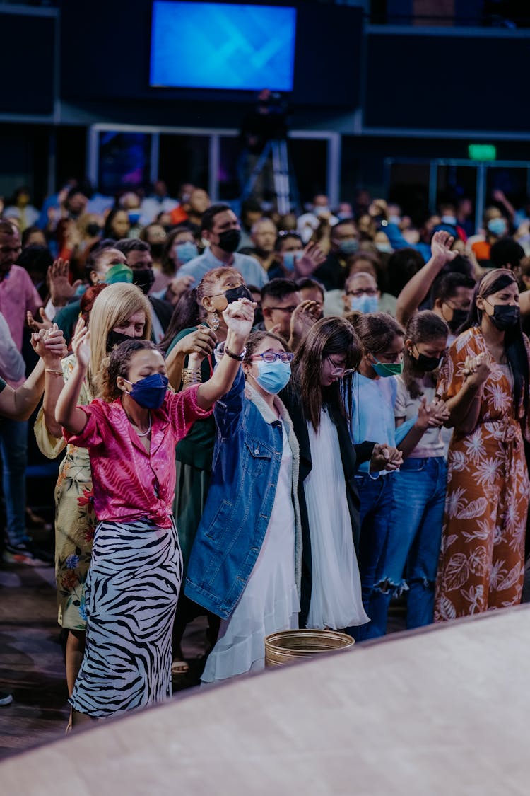 People In Face Masks Singing At Event