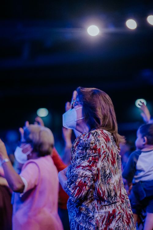 Free A group of people wearing face masks attentively participate in an indoor event, highlighting community and safety measures. Stock Photo