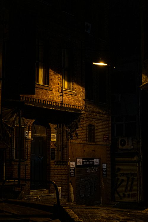 Free Eerie nighttime urban alley with illuminated brick buildings in Istanbul. Stock Photo