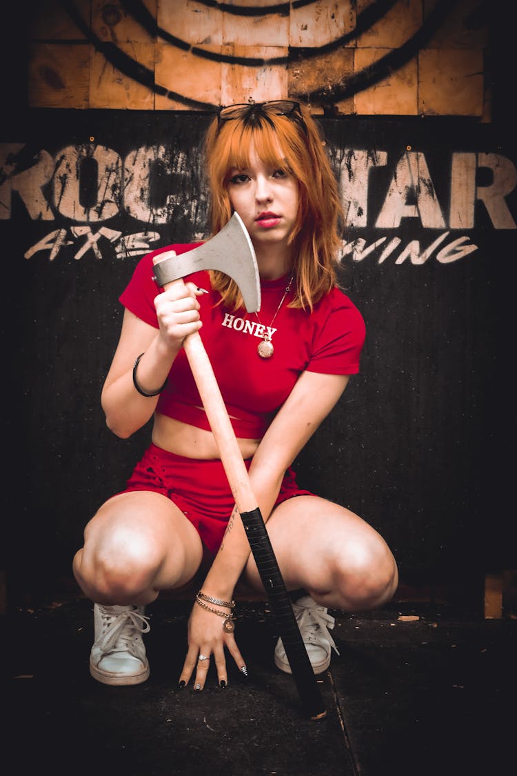 Brunette Woman In Red T-shirt Holding An Axe