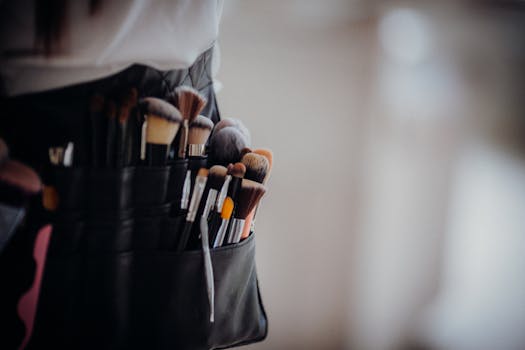Close-up of a collection of professional makeup brushes in a belt, ready for use.
