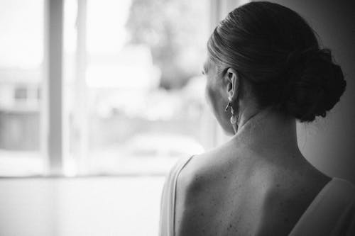 A Grayscale Photo of a Woman Looking Over Her Shoulder